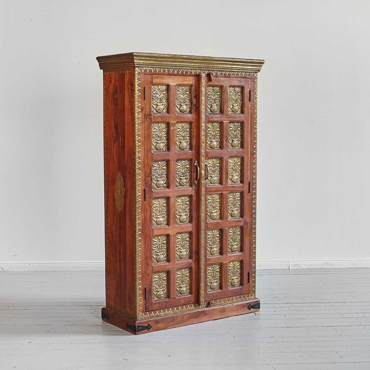 Wooden cabinet with intricate gold carvings on a white background