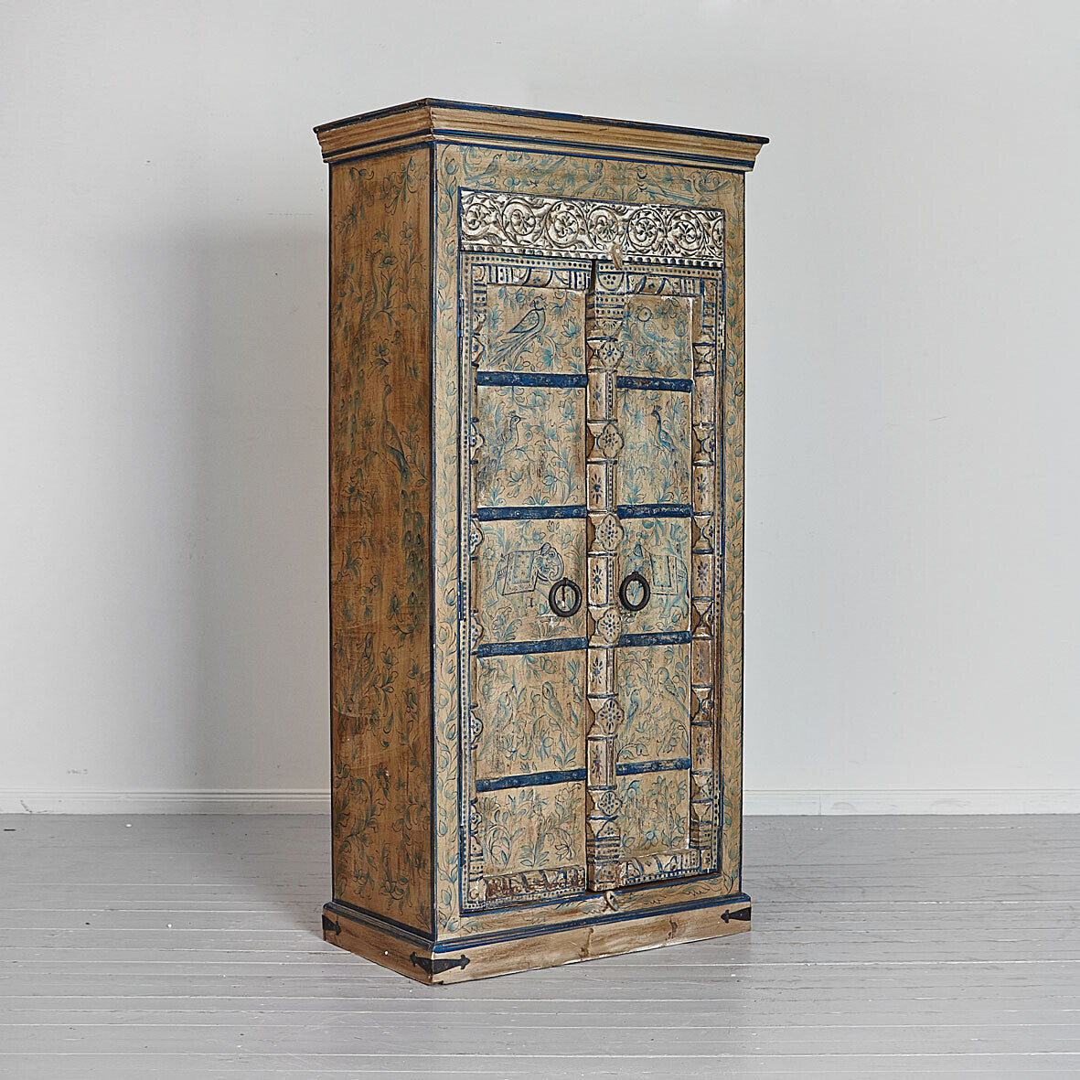 Decorative wooden cabinet with intricate carvings on a plain background