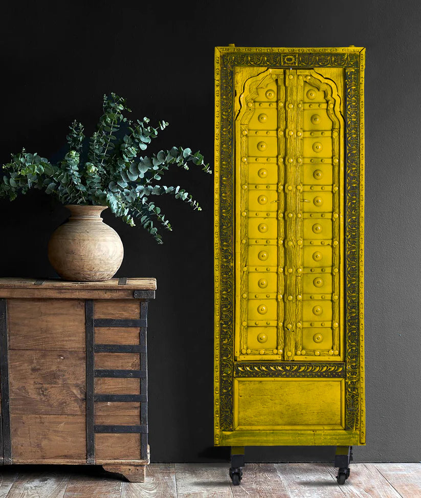 Hand-carved Indian wooden door with iron stand, distressed yellow finish, 57 × 165 cm.

Decorative solid wood Indian door panel in minion yellow, handcrafted in India.

Tall antique-style Indian door decor with carved border and castor base.