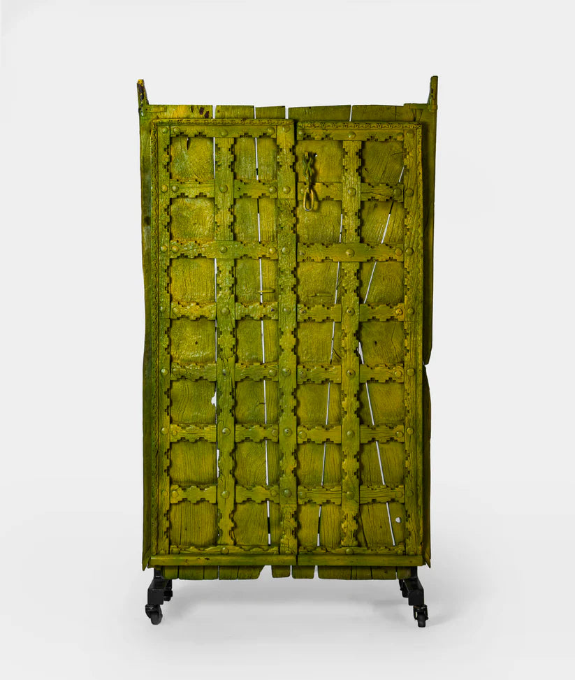 Unique Marwari wooden door with iron stand, distressed olive green finish, 94 × 171 cm.

Handcrafted solid wood Marwari door panel with grid pattern and castor base.

Tall antique-style Indian door decor in olive green, made in India.