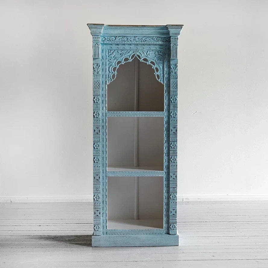 Tall open shelving unit with carved arch, fluted columns, and coastal blue patina.

