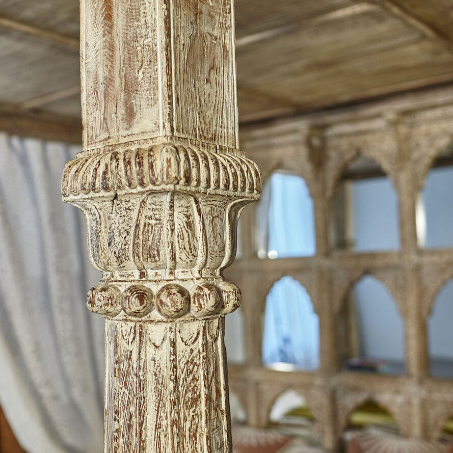 Decorative column with intricate carvings in a historical building setting