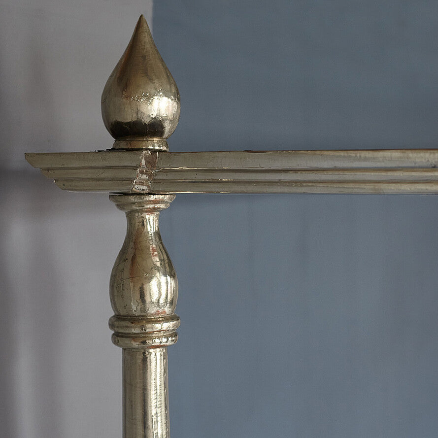 Close-up of a metallic decorative object with a pointed top against a gray background