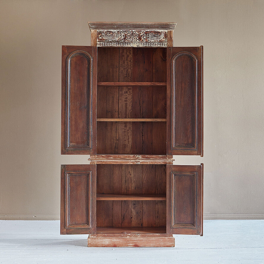 Wooden cabinet with ornate top on a plain background