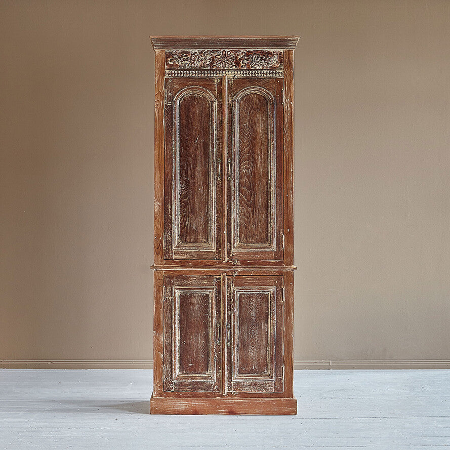 Vintage wooden cabinet with intricate carvings on a plain background