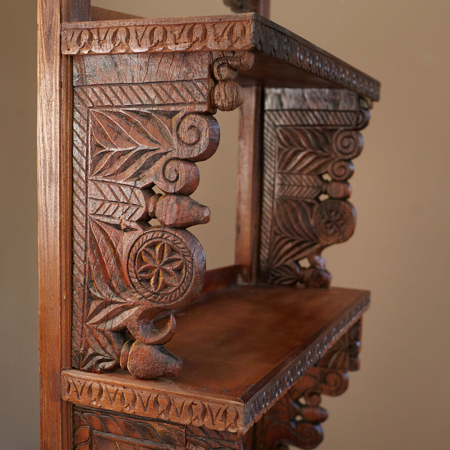 Carved wooden chair with intricate patterns on a plain background