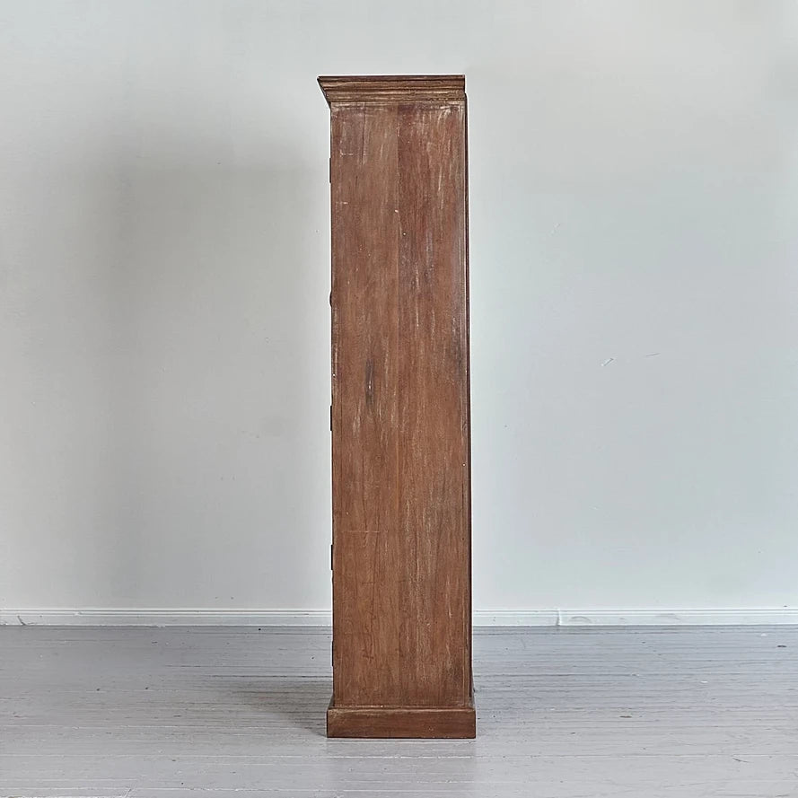 Tall wooden cabinet against a plain white wall