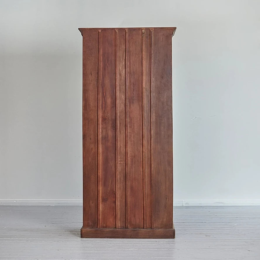 Wooden cabinet with vertical slats on a plain background