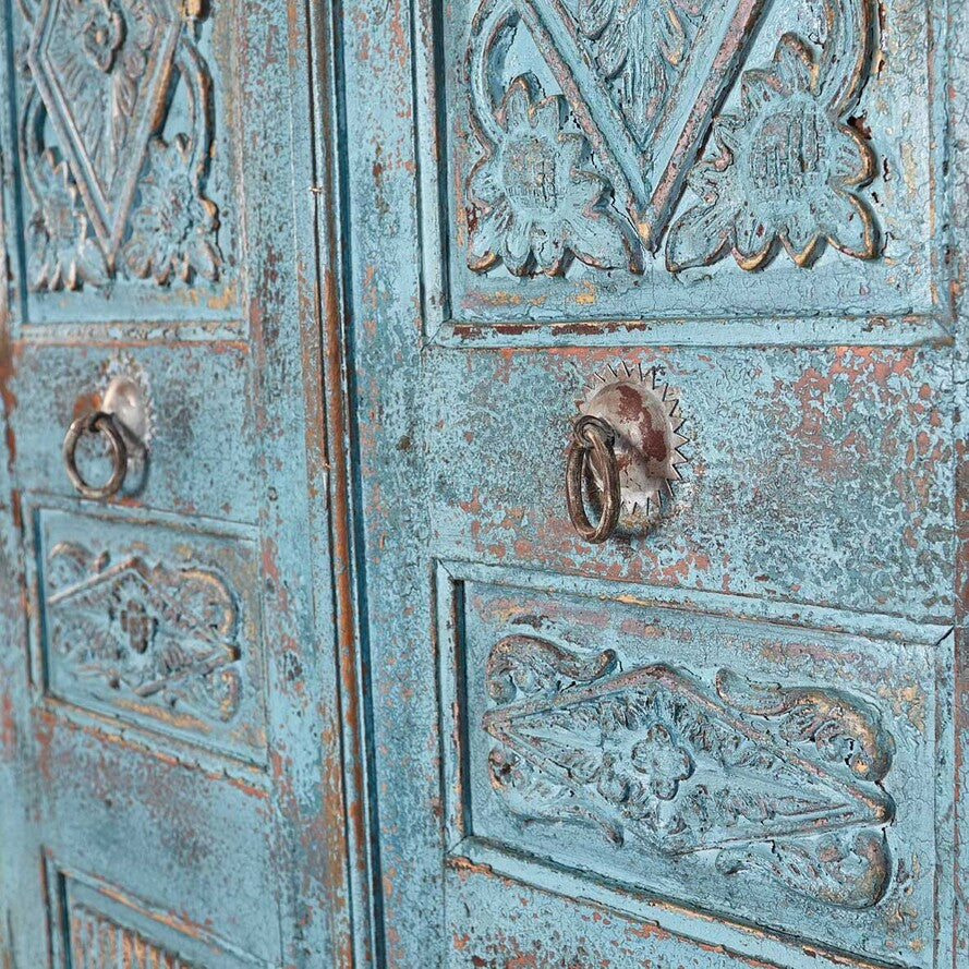 Decorative metal door with intricate patterns and two handles.