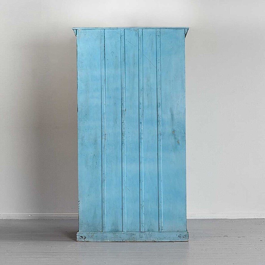 Blue wooden cabinet against a white wall