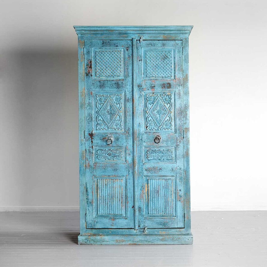 Vintage-style blue cabinet with intricate patterns on a gray background