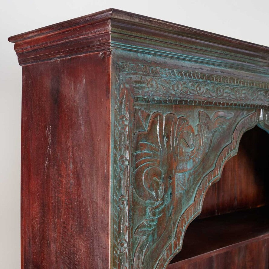 Close-up of an ornate wooden fireplace with detailed carvings.