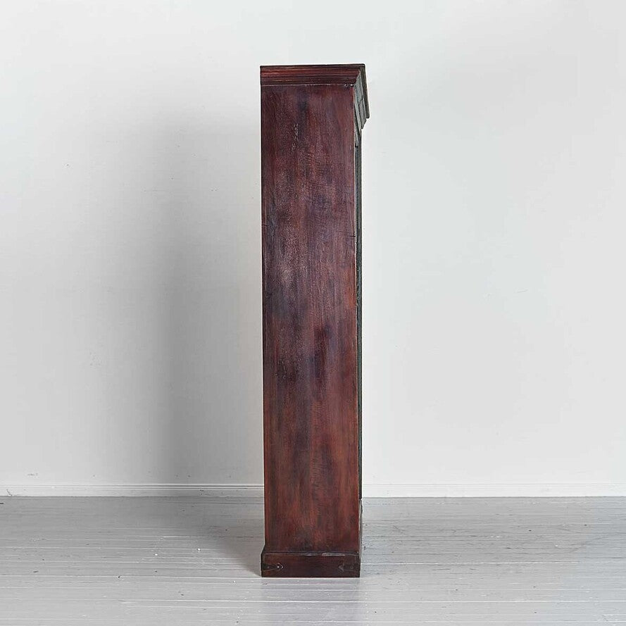 Tall dark wooden cabinet against a white wall