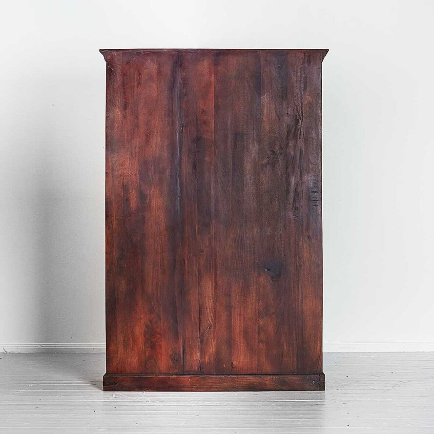 Wooden cabinet with a dark brown finish on a white floor and wall