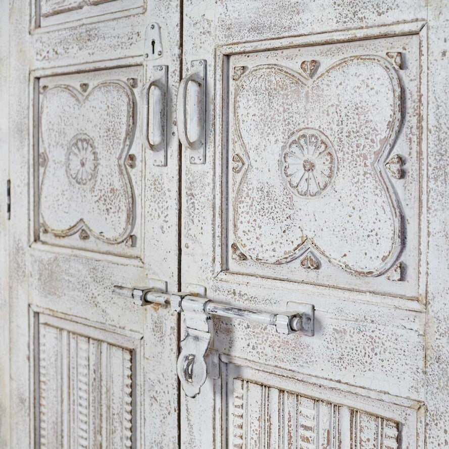 Decorative wooden door with intricate carvings and a metal lock.
