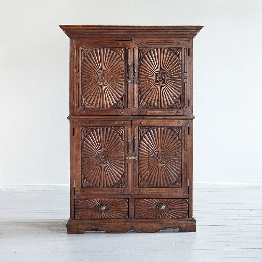 Wooden cabinet with intricate carvings on a white background
