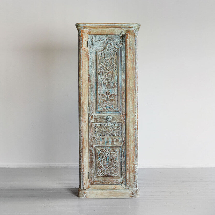 Decorative wooden cabinet with intricate carvings on a plain background