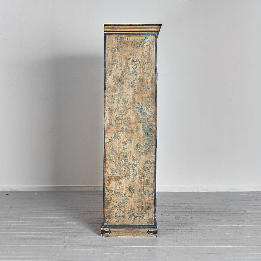 Tall, ornate cabinet with floral patterns on a plain background