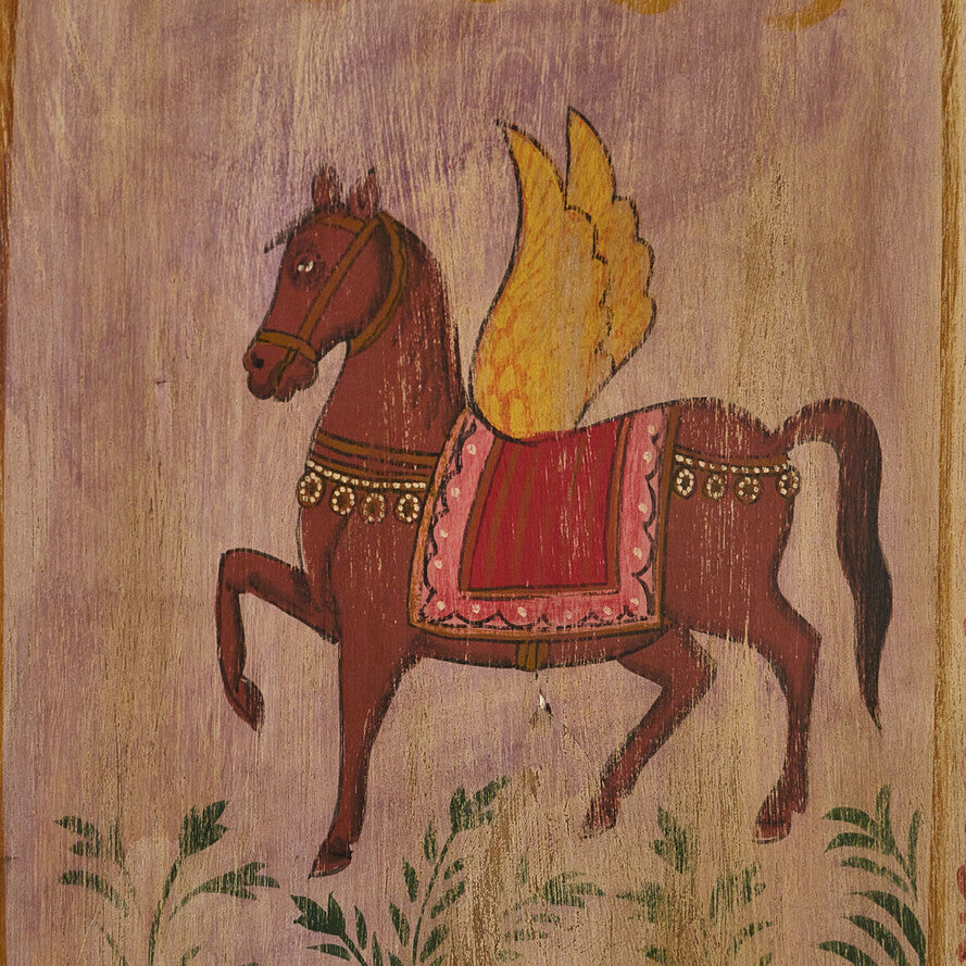 Wooden panel with a painted horse and saddle on a natural background
