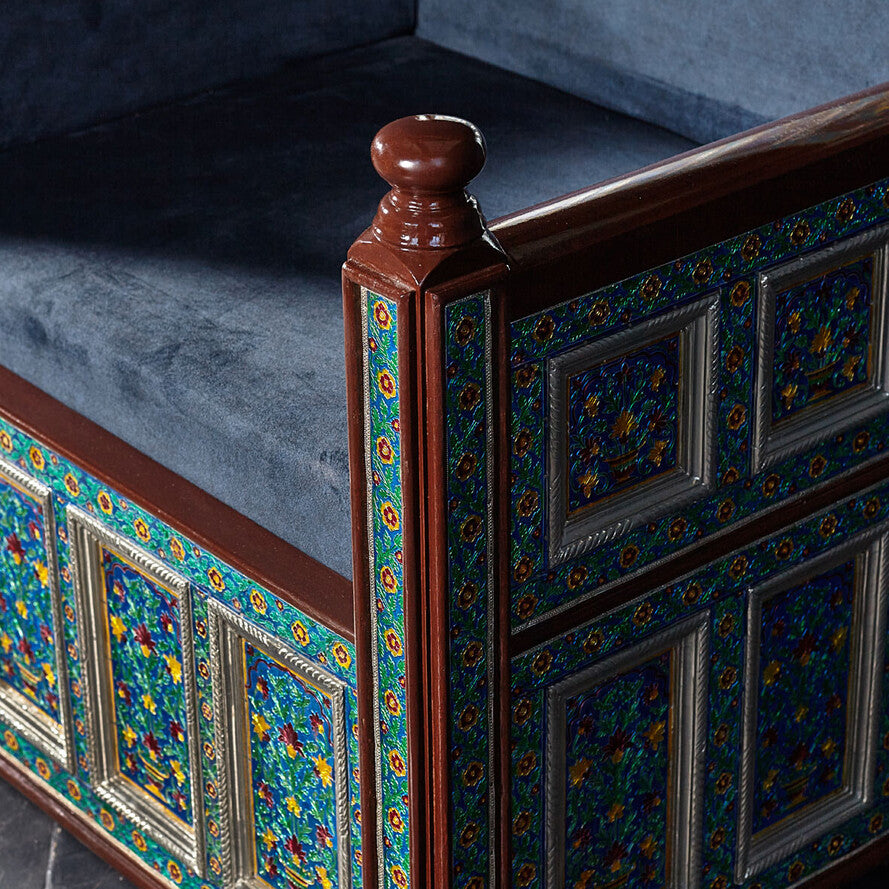 Decorative headboard with intricate patterns and blue cushioned seat