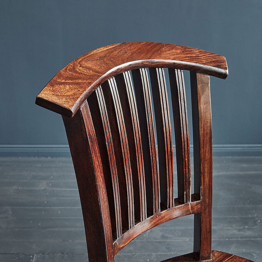 Wooden chair with slatted backrest against a gray background