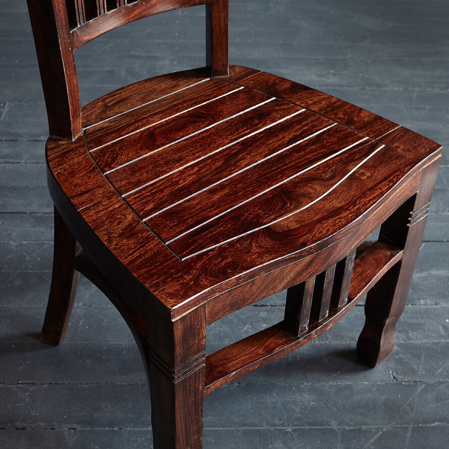 Wooden chair with a dark brown finish on a gray floor.