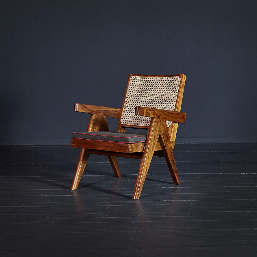 Wooden armchair with wicker backrest on a dark floor and background