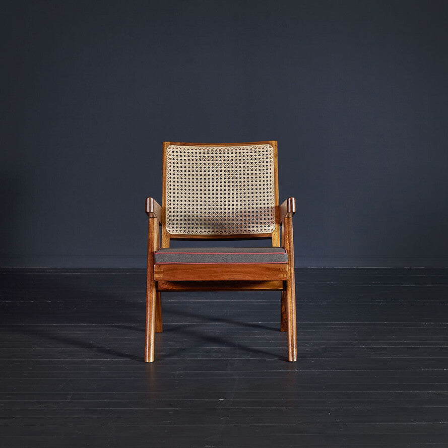 Wooden chair with woven backrest on a dark background