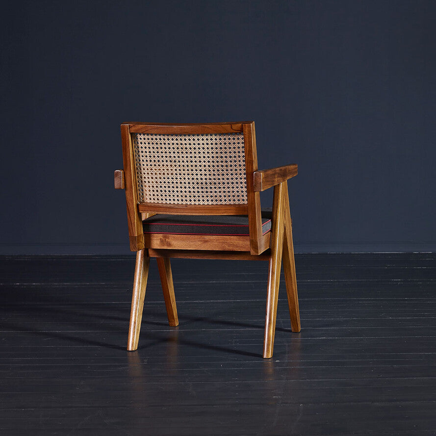 Wooden chair with woven backrest on a dark floor and background