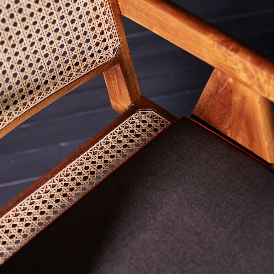 Close-up of a wooden chair with intricate lattice work on a dark background