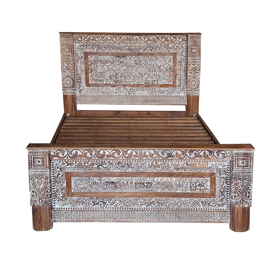 Wooden bed with intricate carvings on a white background