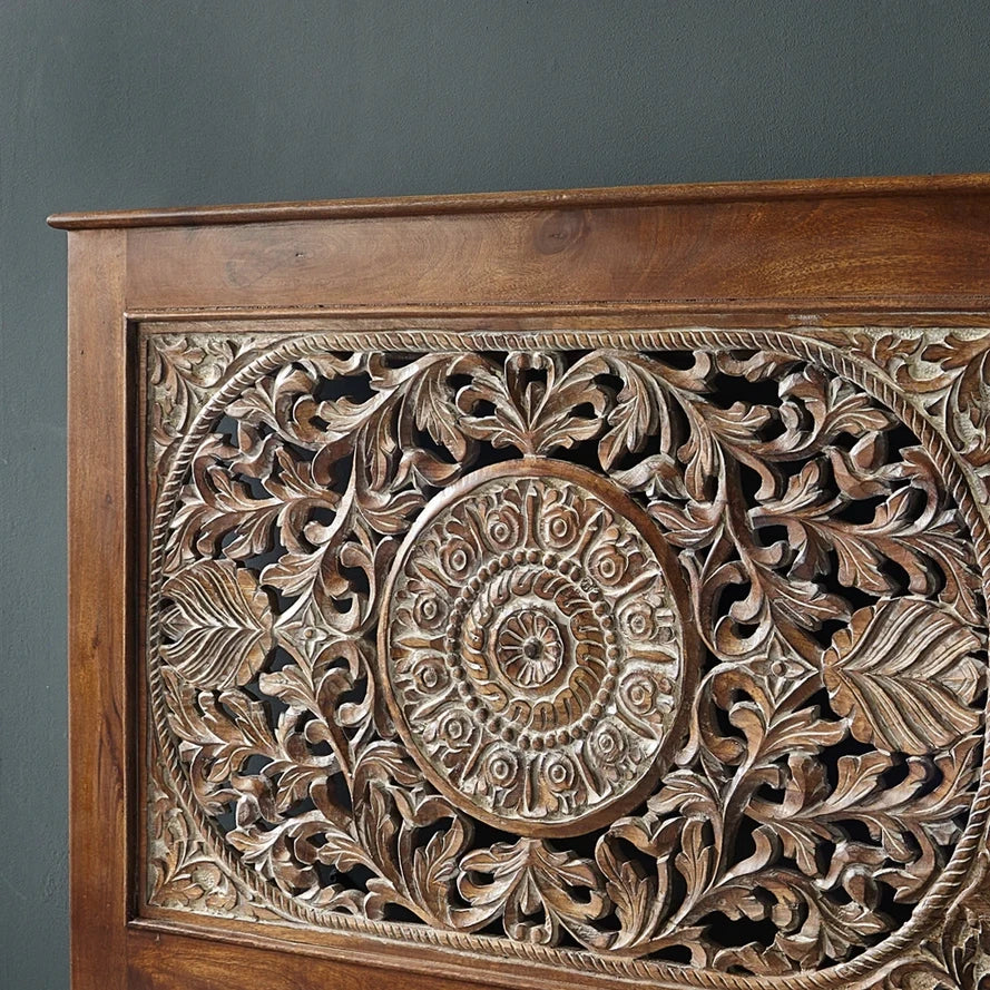 Carved wooden panel with intricate patterns on a gray background